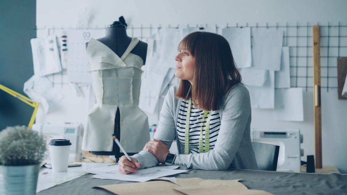 services-03 A fashion designer plans new creations in a modern studio setting.